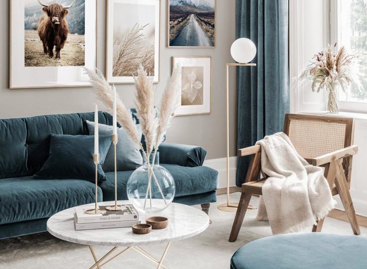 salon beige, canapé en velours bleu, fauteuil en cannage et fleurs séchées