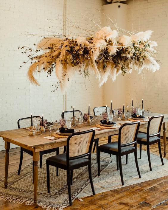 lustre en fleurs séchées et herbe de la pampa dans un salon au meubles en cannage