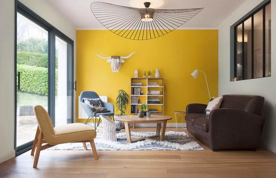 Un salon lumineux avec un pan de mur jaune illuminating