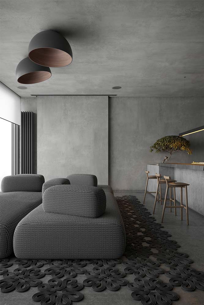 Salon minimaliste et contemporain avec du mobilier rond, murs et plafond en béton brut