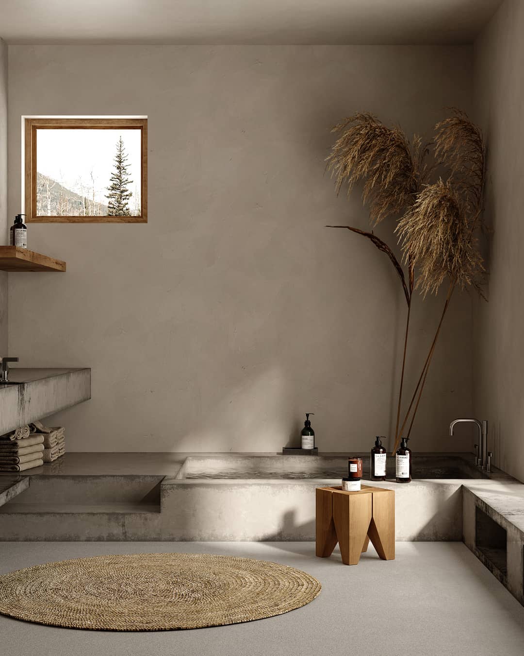 Une salle de bain slow design avec baignoire en pierre, tapis rond, herbes de la pampa et couleurs douces et neutres