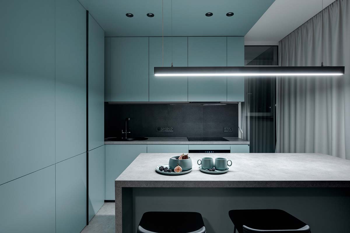 Une cuisine minimaliste avec des murs et des placards en blue sky et une table centrale grise