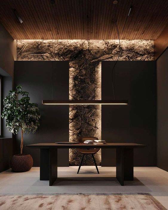 Un bureau de travail avec un mur en pierre, un plafond en bardage intérieur et un bureau en bois noble