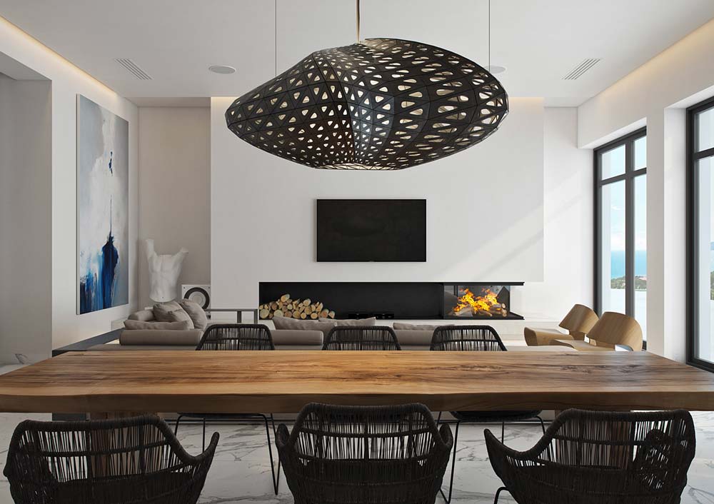 Une salle à manger bord de mer lumineuse avec une grande table en bois, des sièges en osier et un luminaire imitation huître