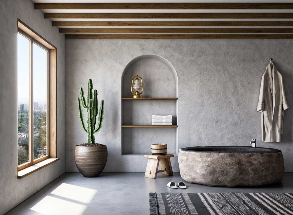 Une salle de bain en tadelakt avec une baignoire ronde en pierre et de la petite déco naturelle en bois