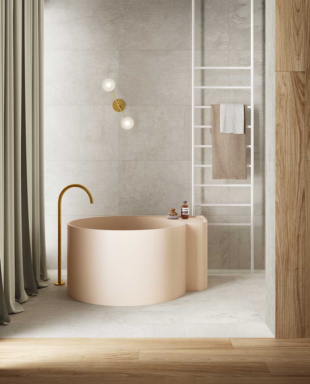 Une salle de bain avec une baignoire ronde rose pâle, du carrelage gris et des planches de bois décoratives