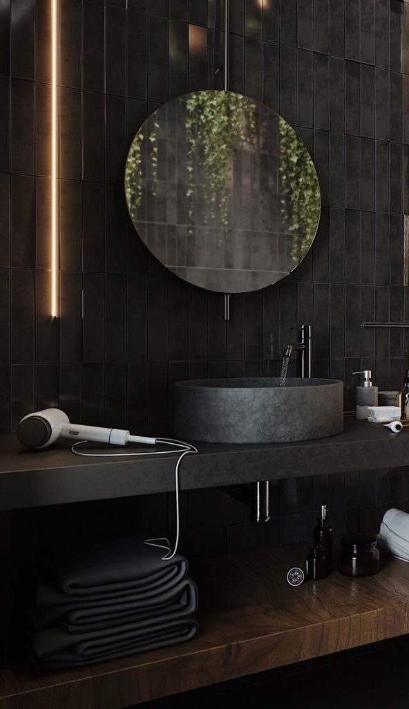 Salle de bain look total black avec une étagère en bois sombre, un miroir rond et un néon lumineux