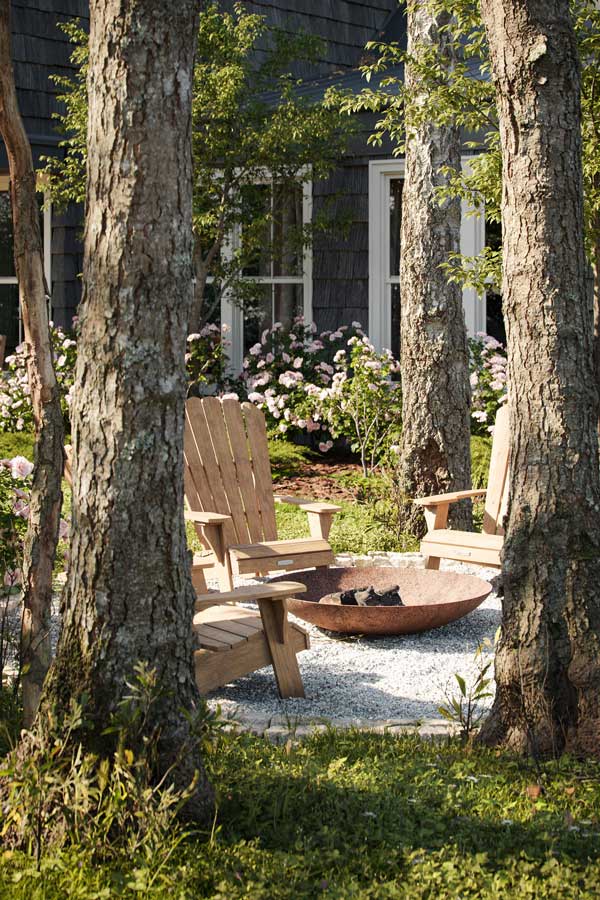 De confortables chaises en bois dans le jardin pour profiter de la nature et du brasero