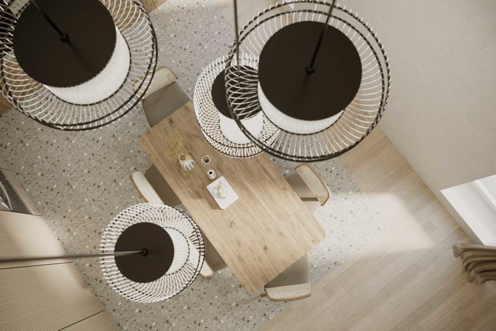 Une salle à manger en terrazzo et bois blond avec des luminaires suspendus en fer noir et blanc