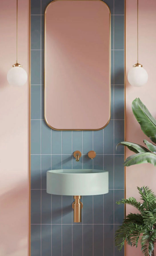 Une vue sur une salle de bain girly aux nuances rose poudrée et bleu ciel avec des touches de cuivre chatoyant dans la petite décoration ; la robinetterie, les luminaires...