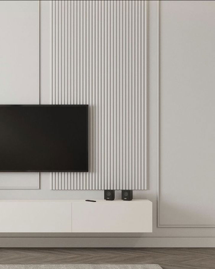 Salon minimaliste avec une TV et des moulures verticales et arrondies de teinte crème, le parquet est en point de Hongrie