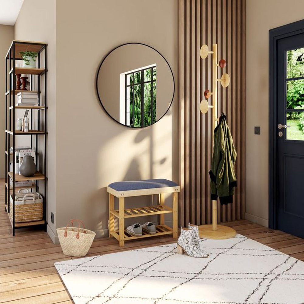 Entrée d'une maison avec un tapis en justes pour délimiter la zone. Miroir qui permet de refléter aussi la lumière qui rentre par la porte, le tout contrasté par un bardage en bois.