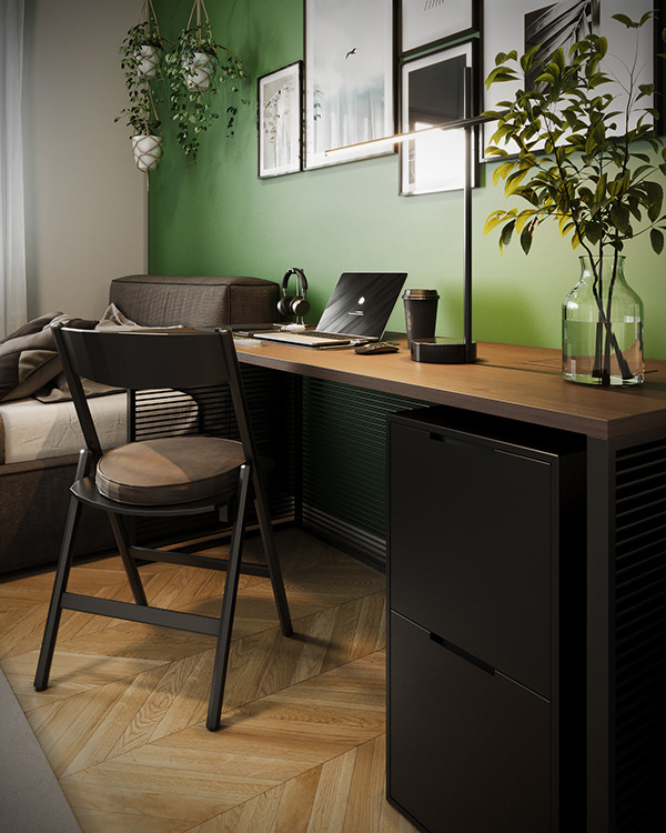 Bureau dans une chambre, avec une décoration entourée d'éléments noirs, comme la chaise, les tiroirs, les cadres des tableaux accrochés sur le mur vert forêt.