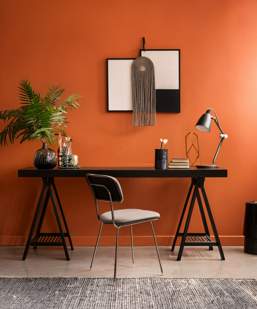 Bureau de chambre avec un mur de fond orange et du mobilier noire.