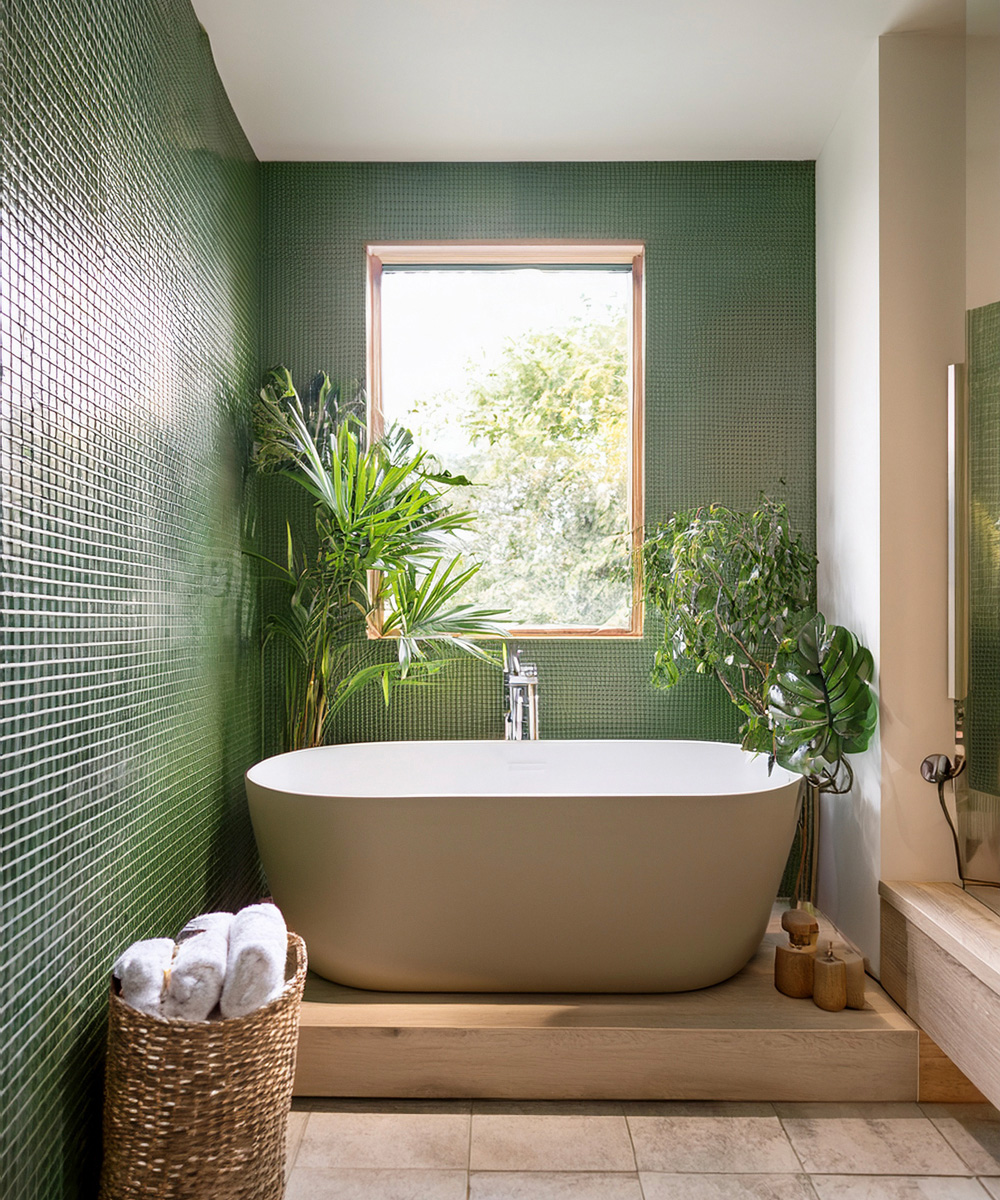 Salle de bain faïence avec des petits carreaux verts et une baignoire centrale surélevée côté fenêtre.