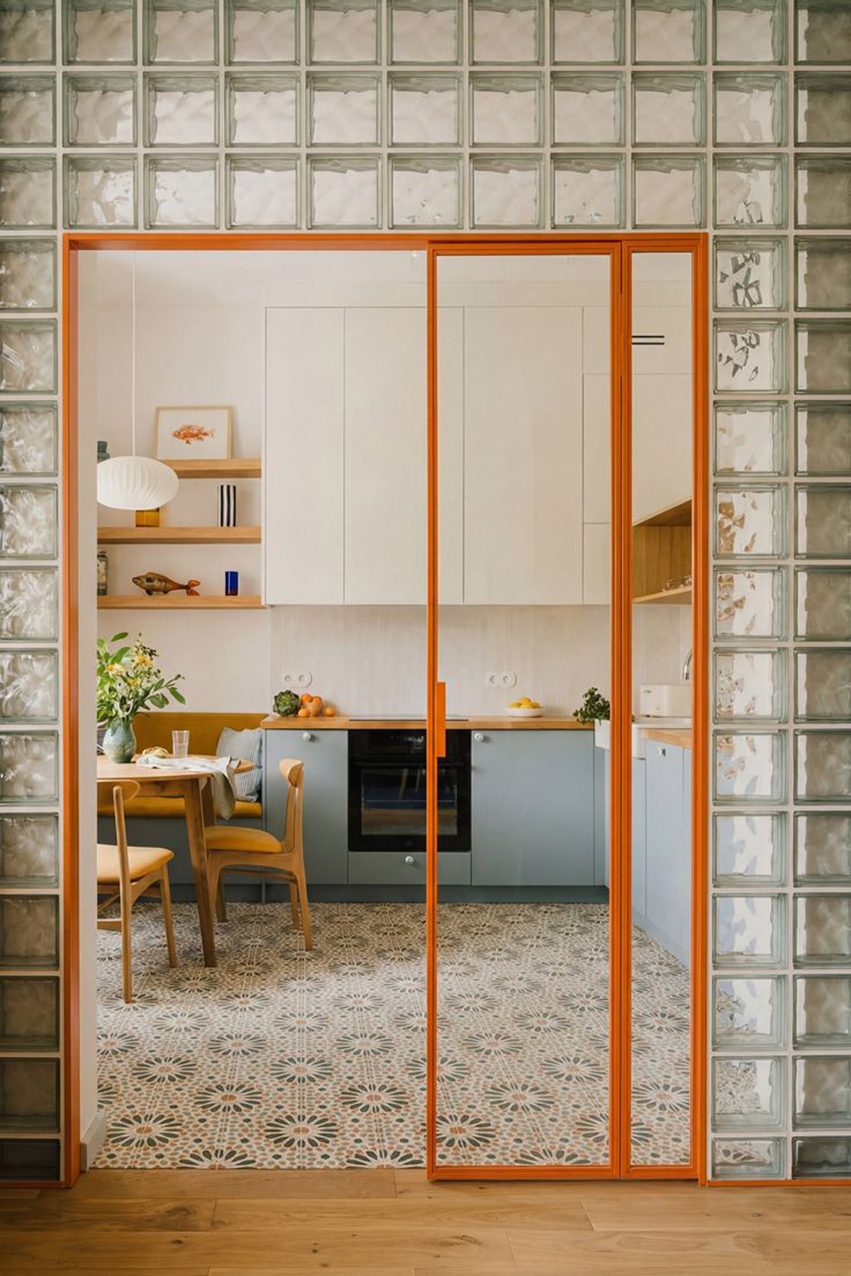 Petite séparation salon, cuisine avec en contour de la porte coulissante des cube de verres floue.