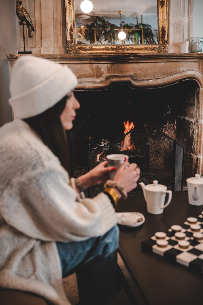 Cliente qui profite de la cheminée assise sur le canapé dans l'espace salon d'un hôtel.