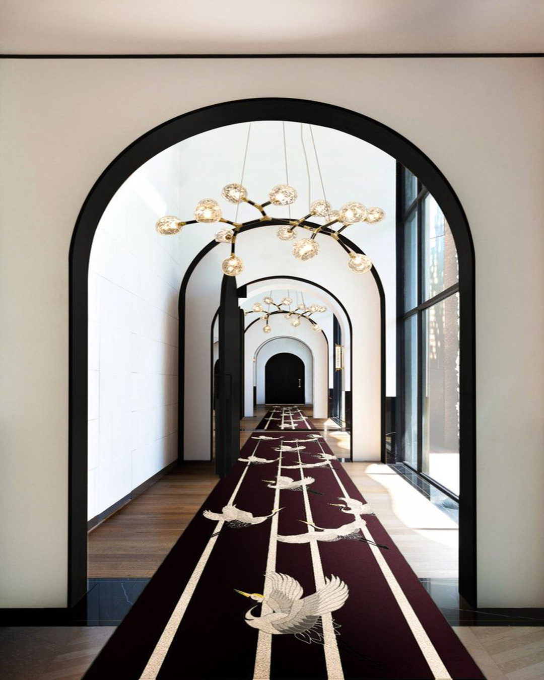 Couloir d'un établissement avec tapis couleur bordeaux avec des cigognes dessus.