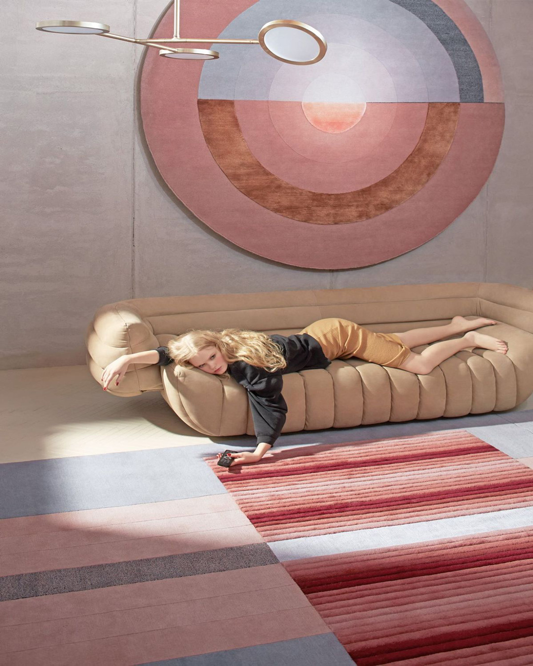 femme allongé dans un canapé, qui touche le tapis avec de la laine par dessus un tapis plus lisse et robuste.