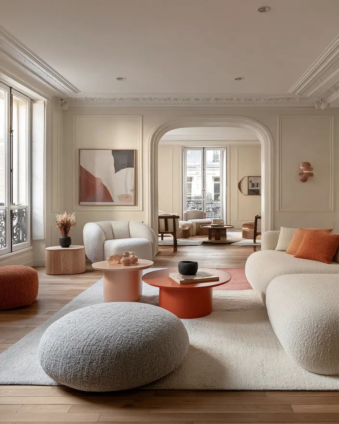 Salon d'appartement parisien entouré de décoration arrondi, avec un tapis de salon rectangulaire pour structuré l'espace.