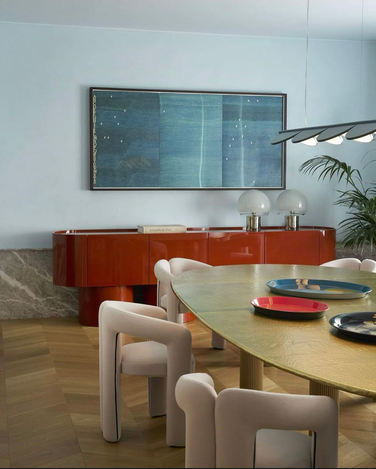 Salon avec salle à manger et commode design rouge foncé brillante.